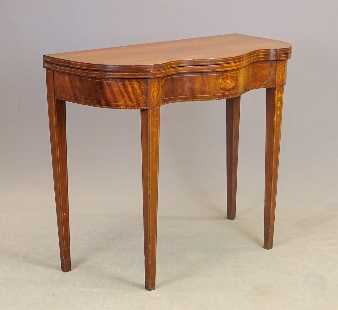 19th c. Inlaid Hepplewhite Card: C. 1800 mahogany inlaid shaped front Hepplewhite card table. Urn inlay on front panel. Legs have bellflower inlay. 35" x 17" x 30" Ht..