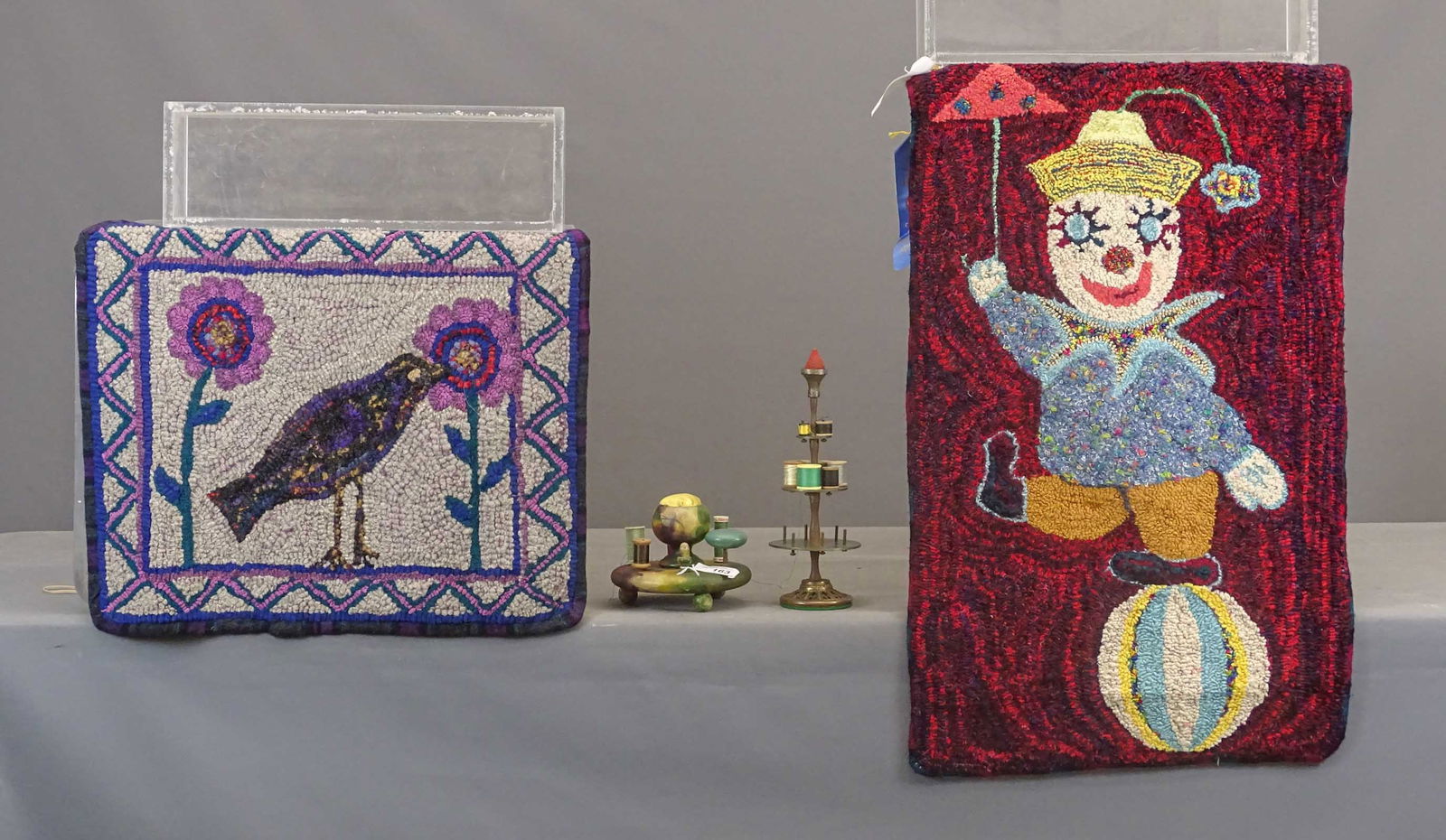 Hooked Rug Lot: Lot (2) contemporary hooked rugs of a clown and another with a bird and blossom (21" x 24" and 21" x 35", together with (2) antique thread holders (5 1/2" and 13" Ht.).