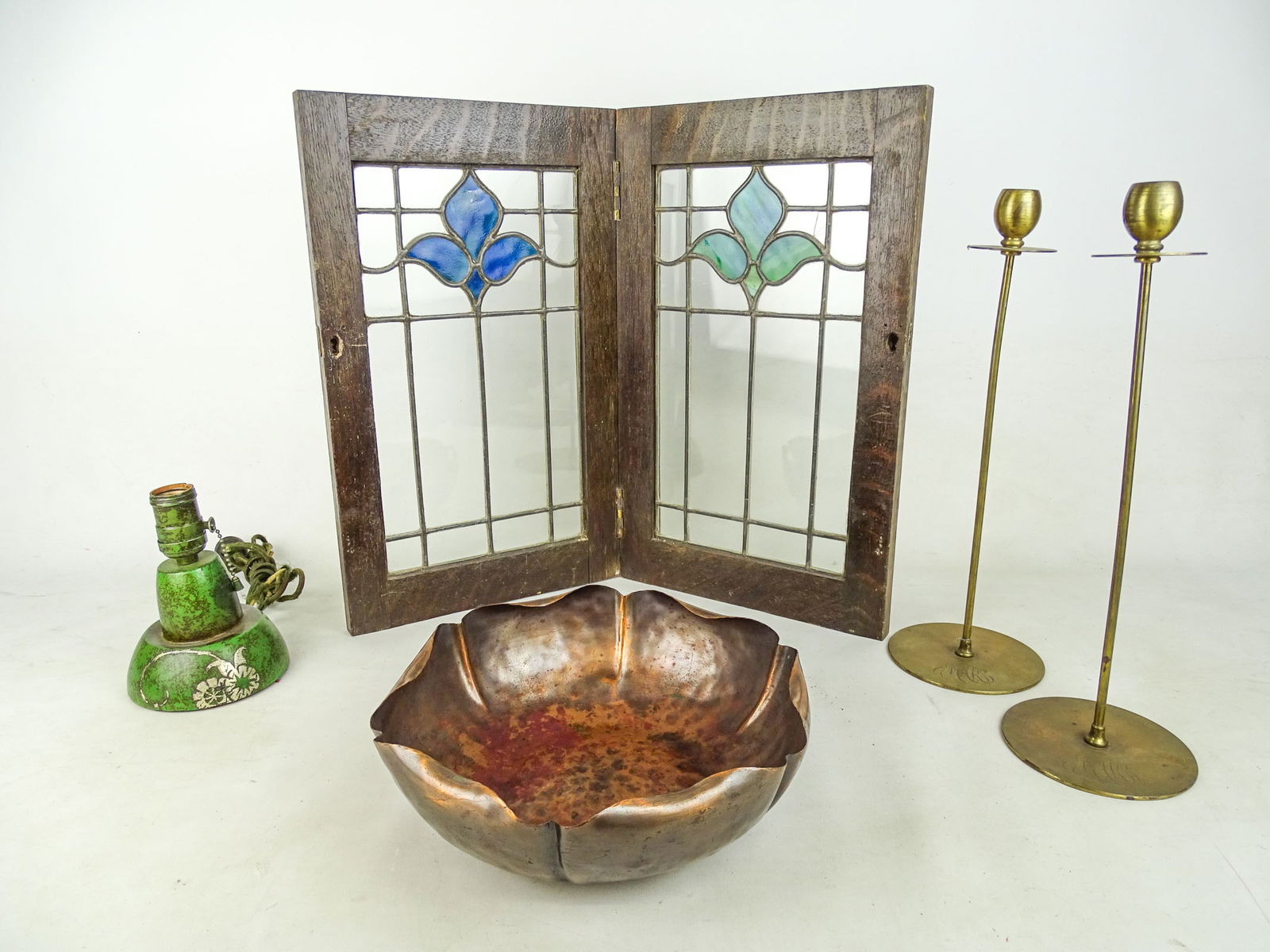 Arts & Crafts Lot: Arts and Crafts period lot including: Bi-fold stained glass (18" x 11"), pair of Jarvie style candlesticks (15 1/2" Ht., monogrammed), copper craft bowl (10 1/2" D.), Heintz bronze and sterling lamp