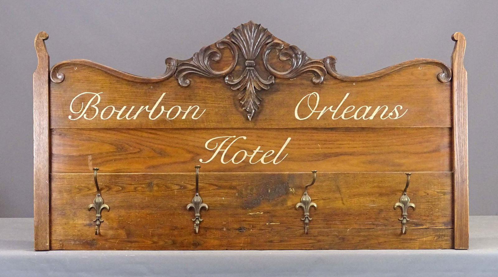 Bourbon Street Hotel Sign: Wooden painted sign "BOURBON ORLEANS HOTEL". With hook racks. Repurposed from Victorian bed. 57" x 29".