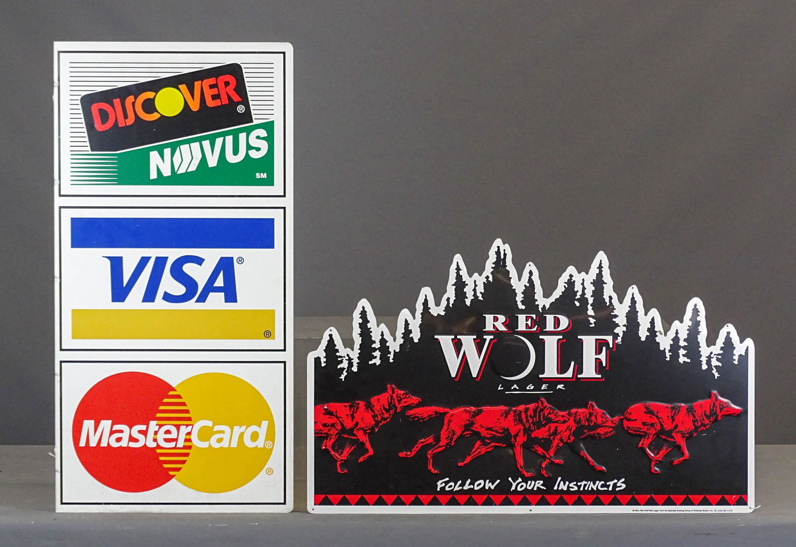 Sign Lot: Lot (2) metal signs including flanged credit card sign (31 1/2" x 16 1/2" and Red Wolf (17 1/2" x 30").
