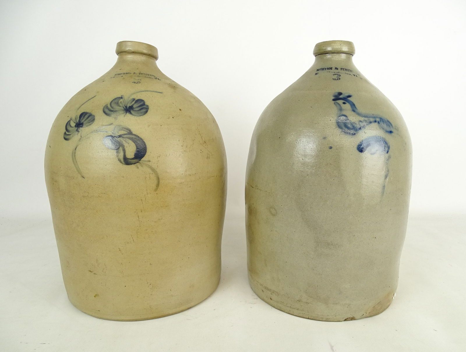 Bennington Pottery Lot: Bennington Pottery Lot: "Norton & Fenton Bennington VT" (3 gal jug with 3 flower decoration, 14 1/4" Ht), "Norton & Fenton Bennington VT" (3 gal jug with bird decoration, 14 1/4" Ht).