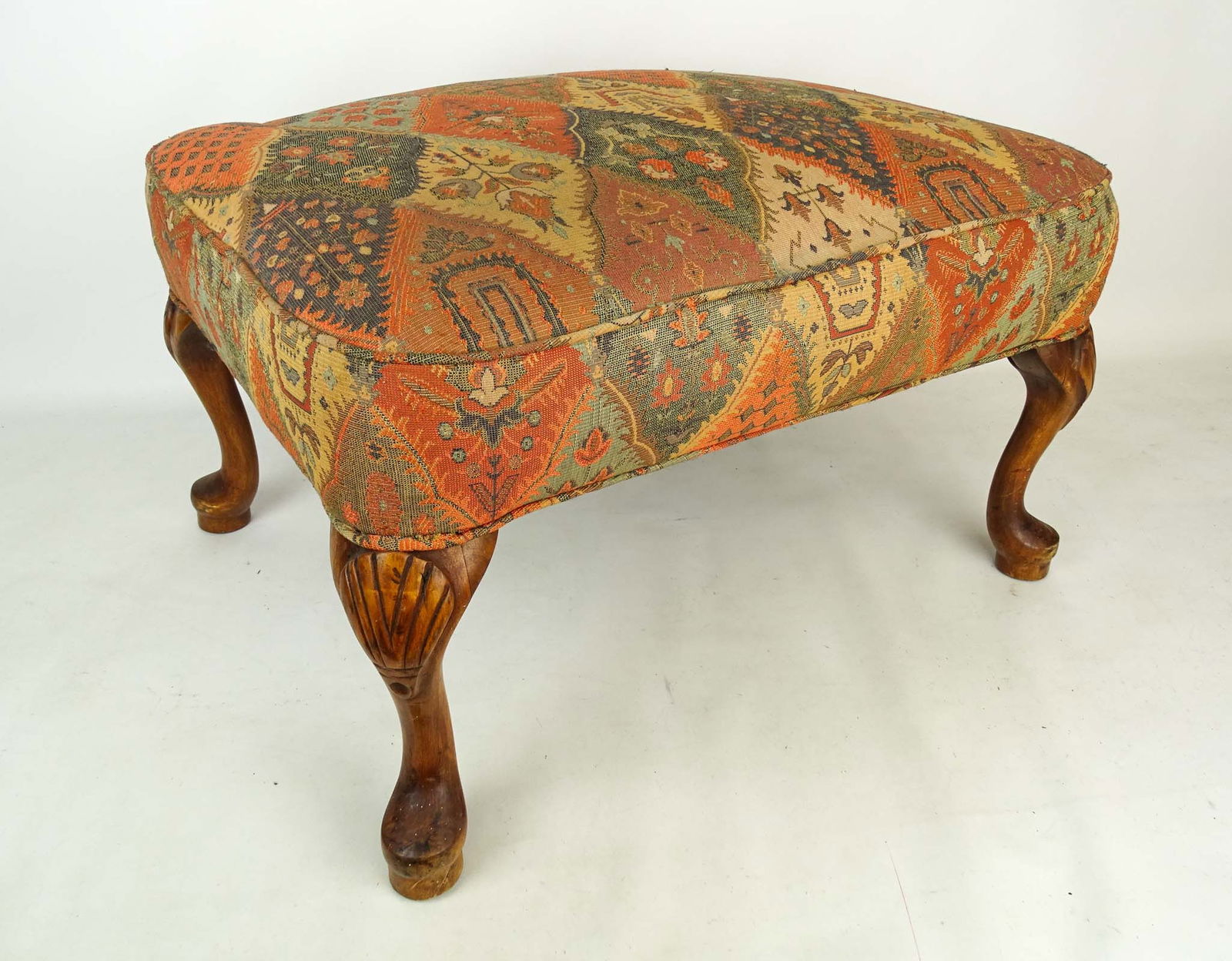 Queen Anne Style Ottoman: Queen style upholstered ottoman with shell carved knees. 25" x 20" x 15".