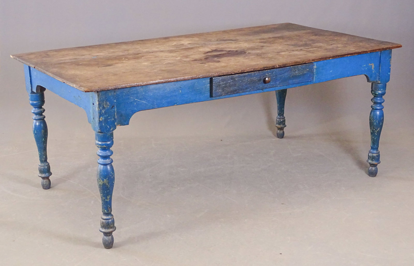 19th c. Farm Table: 19th c. farm table in old blue paint. Single drawer. Note naturally worn top areas. 75" x 40" x 31" Ht., 25" skirt Ht..
