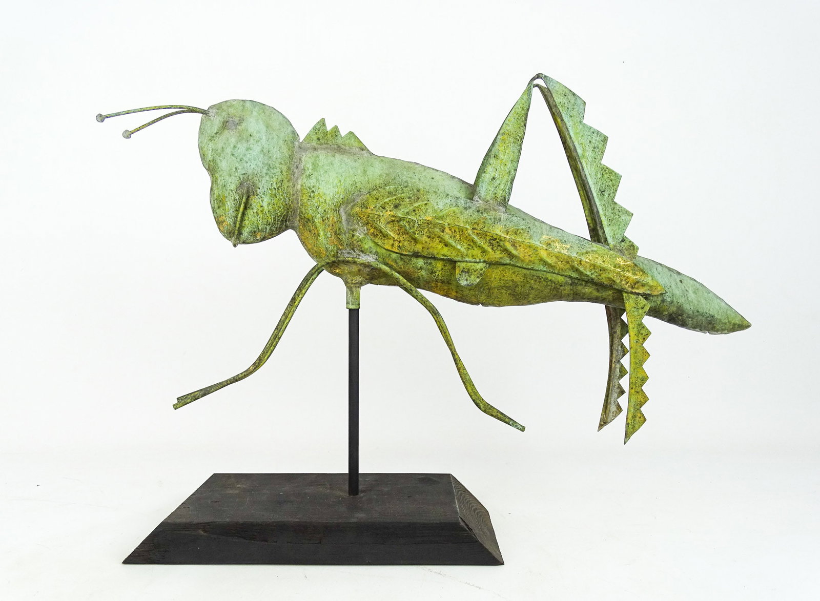 Grasshopper Weathervane: Grasshopper weathervane in verdigris patina. Wooden base included. 24 1/2" x 12".