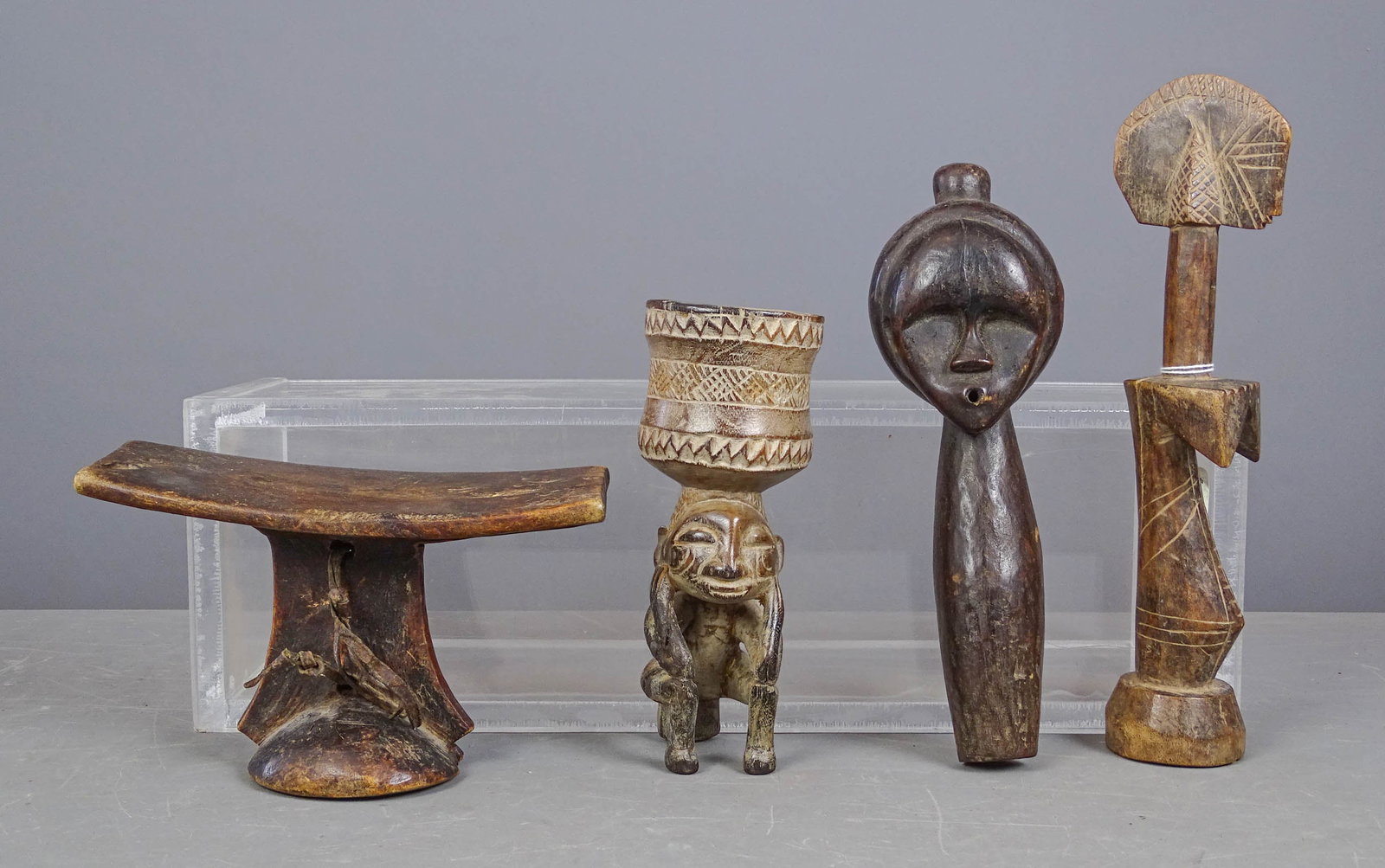 African Lot: Lot of African carvings including: Fang Reliquary (10" L.), Ethiopian head-rest (8" W., 5" Ht.), Kuba ceremonial cup (8" Ht.), Mossi child's doll (12" L.).