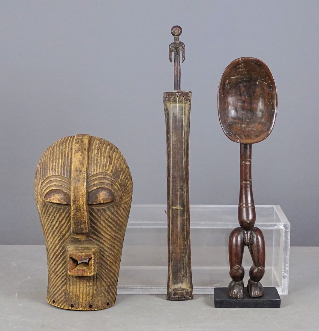 African Lot: Lot of African carvings including: Songe mask (13" L.), Dan ceremonial spoon (20" Ht.), Yorba instrument (23" L.).