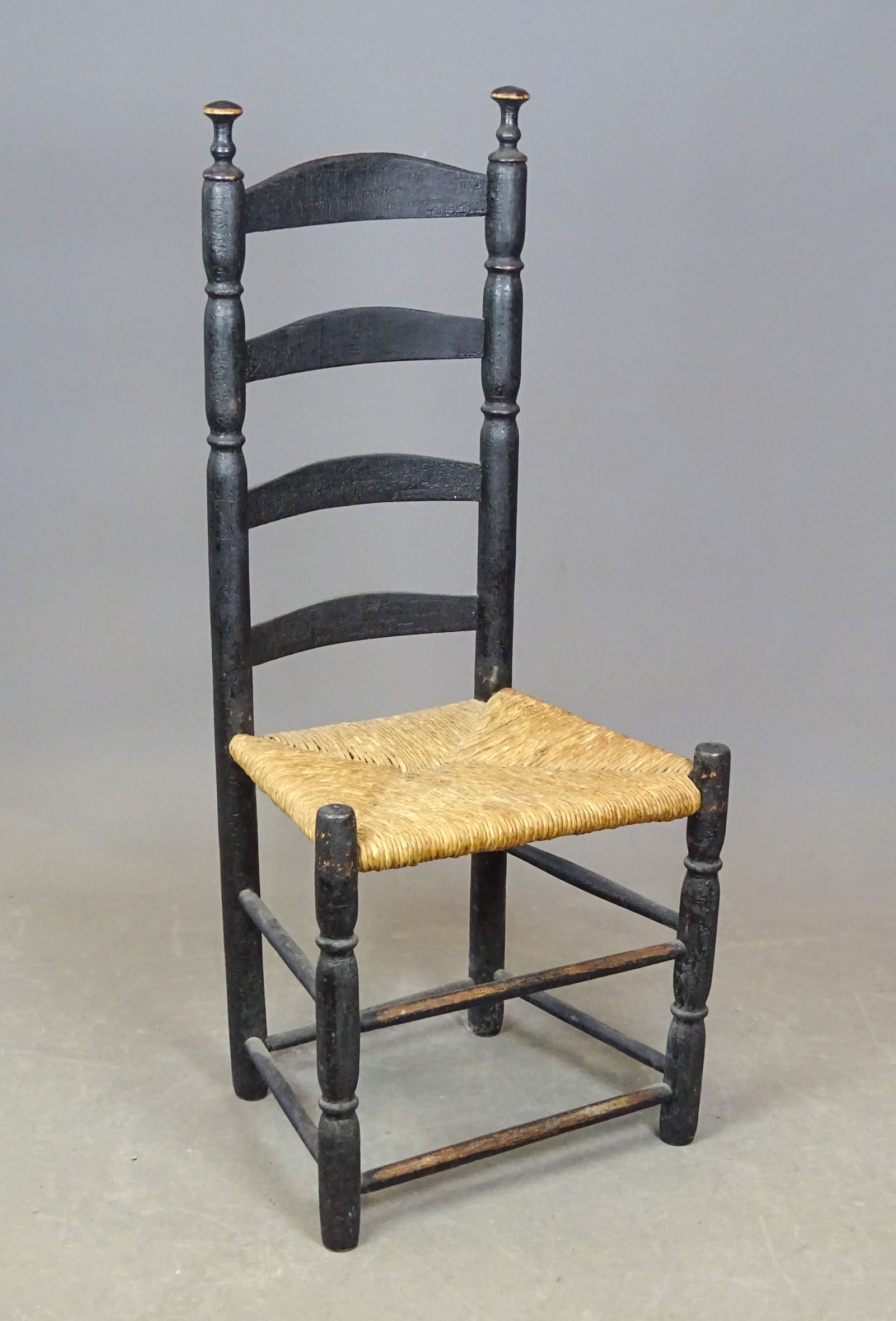 18th c. New England Ladderback Chair: 18th c. New England ladderback chair with rush seat. 18" seat Ht., 44 1/2" overall Ht.. Old black paint surface.