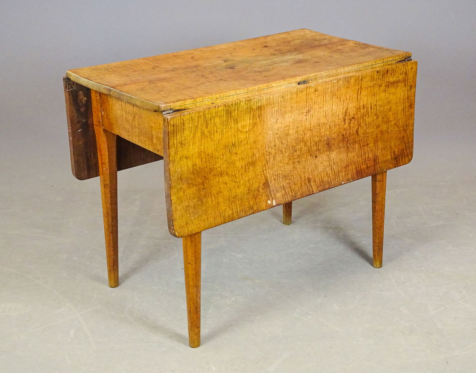 19th c. Dropleaf Table: 19th c. tiger maple dropleaf table having shaped tapered legs. 36" x 19 1/2" with 12 3/4" leaves, 28" Ht..