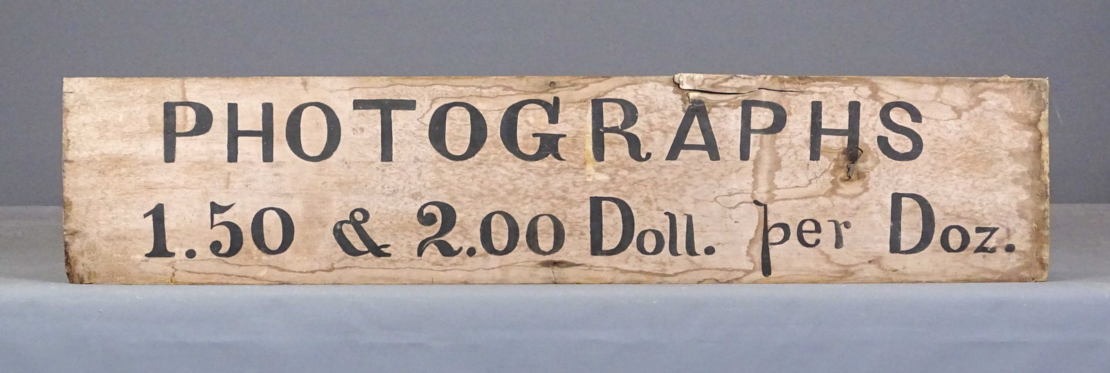 Trade Sign: Painted wooden trade sign "PHOTOGRAPHY 1.50 and 2.00 Doll. Per Doz.". 10" x 46".