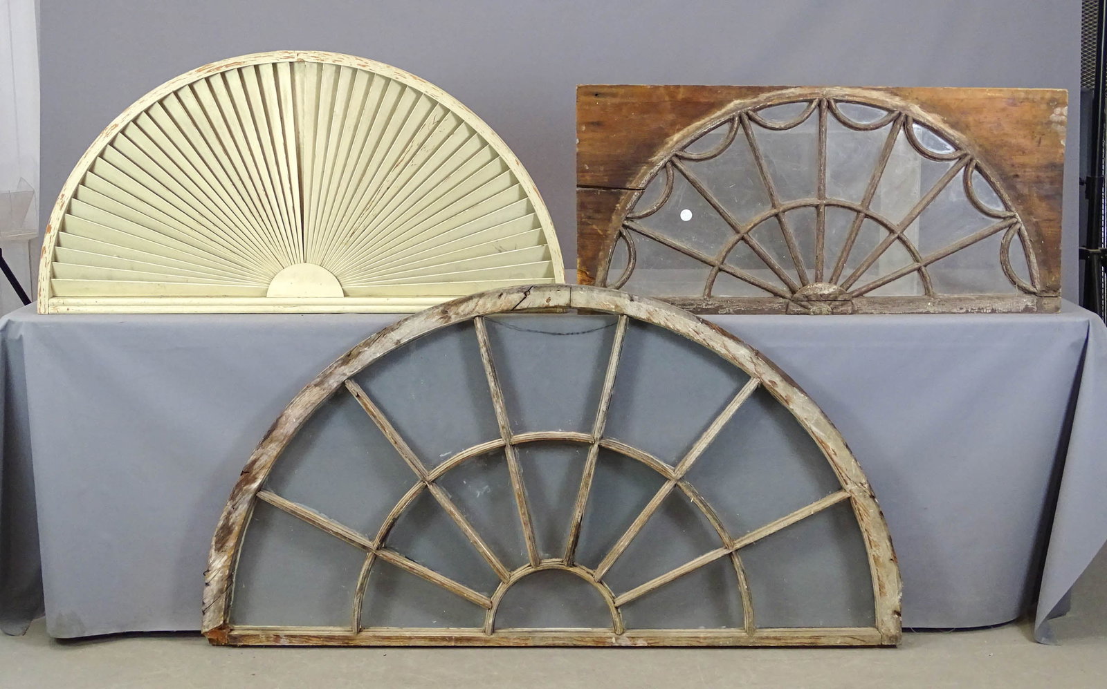 Transom Windows: Lot (3) transom windows. Includes: wooden fan (46" x 23 1/2"), spiderweb-sunburst (42 1/2" x 20"), sunburst (60 1/2" x 32").
