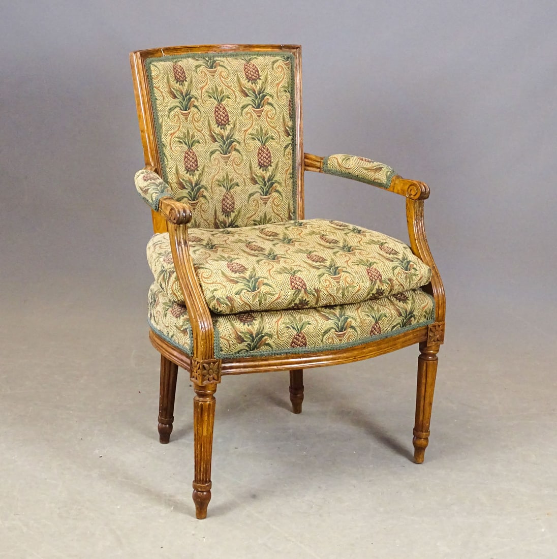 French Louis XVI Armchair: French Louis XVI style walnut armchair having pineapple patterned tapestry upholstery. 18" seat Ht., 32 3/4" Ht..