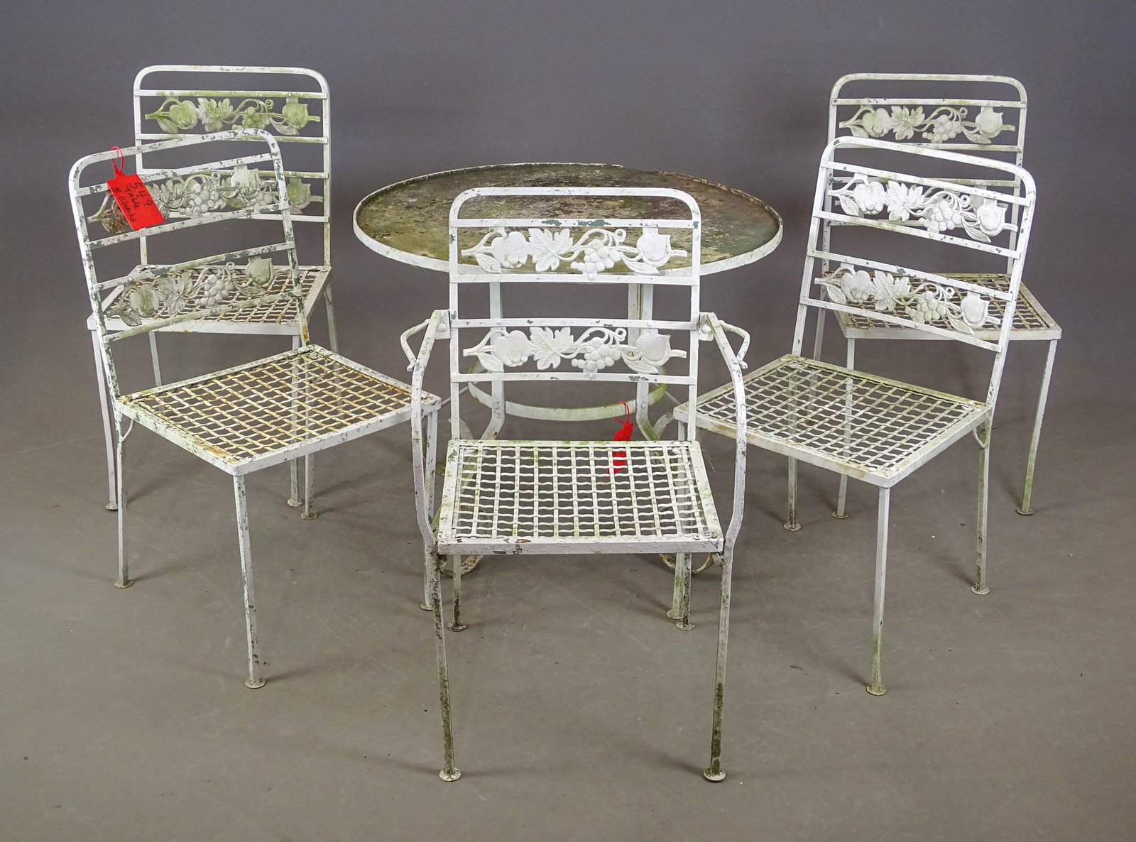 Patio Set: Iron patio set. (5) chairs (grape pattern, 16 1/2" seat Ht., 32 1/2" overall Ht.), table 32 1/2" D., 25 1/2" Ht.).