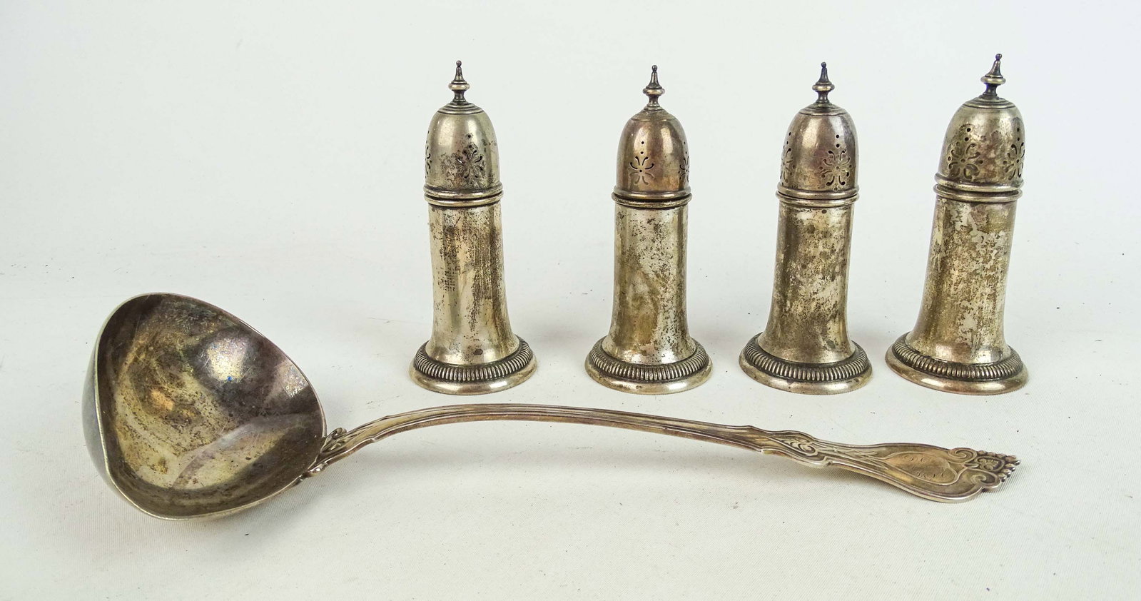 Sterling Silver Lot: Sterling silver lot: 4 salt and peppers (5" Ht., 259 grams), silverplate ladle (12" L.).