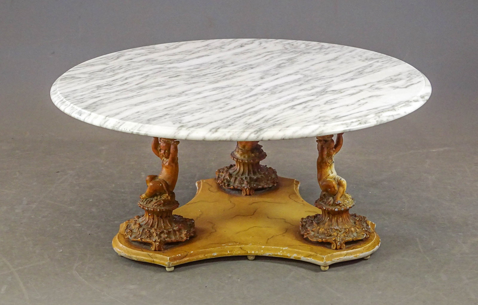 Vintage Marble Top Coffee Table: Vintage marble top coffee table with metal Putti figures. 34" D., 17" Ht..