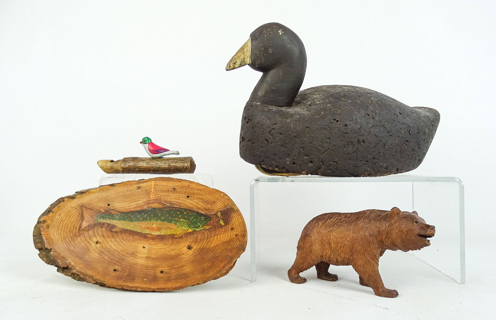 Decoy Lot: Lot including: Carved and painted wooden decoy (12" L., cork body), painted fish plaque (10" L.), carved wooden bear (7" L.), bird whistle (5" L.).