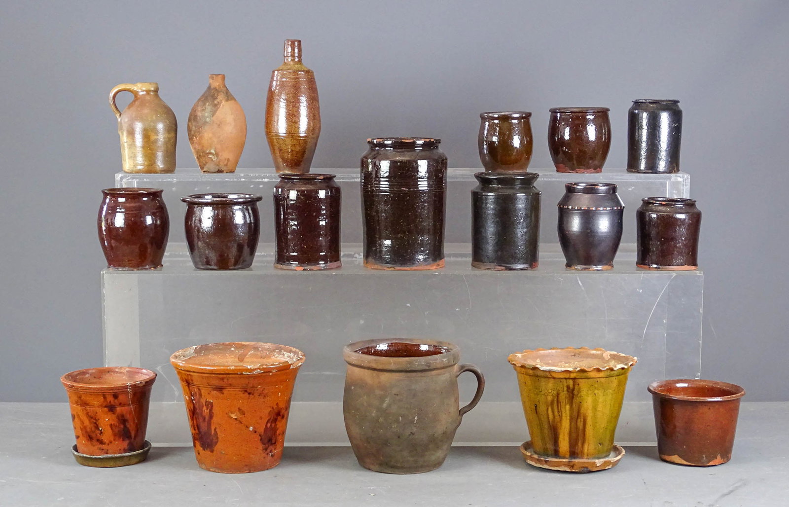 Redware Lot: Lot (18) pieces of 19th c. redware including: Flower pots, bottles, jars. Largest 8 1/2" D., 7 1/2" Ht.. Imperfections.