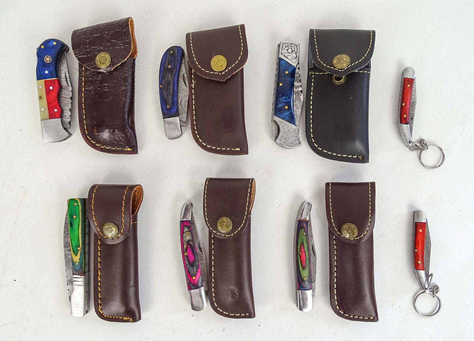 Lot of Handmade Knives: Lot (8) handmade pocket knives with sheaths. Longest 4 1/2" L.