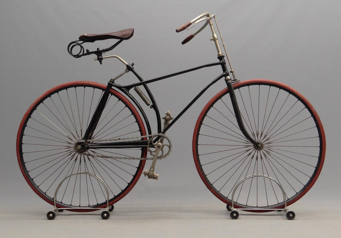 Hard Tire Safety: C. 1890 hard tire safety men's bicycle. Lugged split frame, rear levered sprung suspension. Features saddle, pedals, brake, saddle, tires, grips. SN# 328. 21" frame size. 31" wheels. Note mid tensione