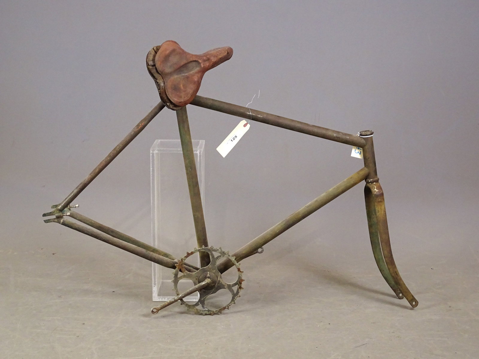 Unknown Maker Frame: Unknown maker: the frame is complete with no dents. The only parts attached to this frame are the bottom bracket with pedal arms and a chain ring. The seat post and saddle cover (not useable) remain.