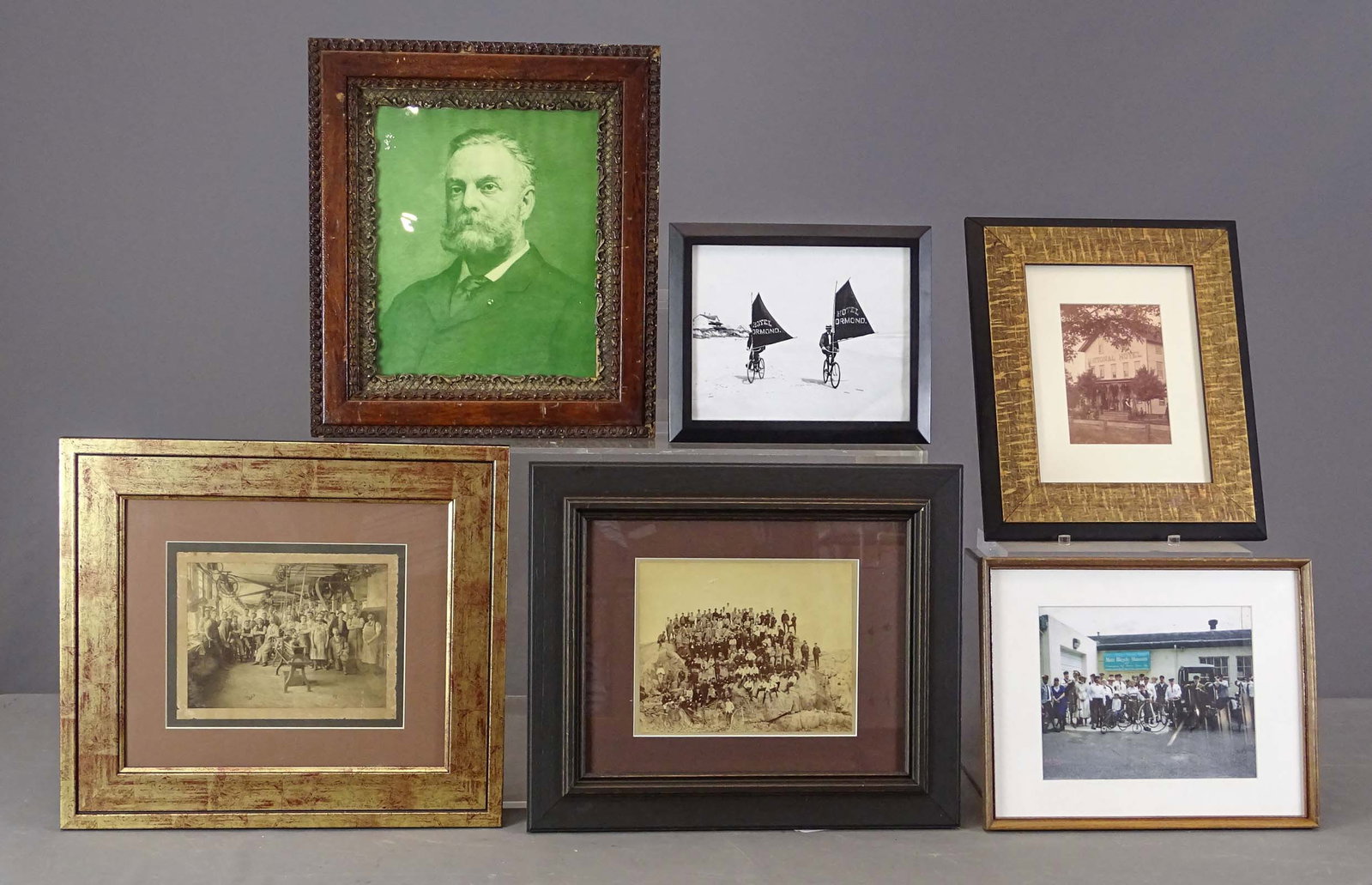 Bicycle Artwork Lot: Lot including: Framed print of Pope (overall 17" x 15"), Wheelmen group photo (16" x 18 1/2"), interior shop photo (16 1/2" x 18"), Metz Museum photo, Hotel Ormond banner riders, National Hotel. Gary