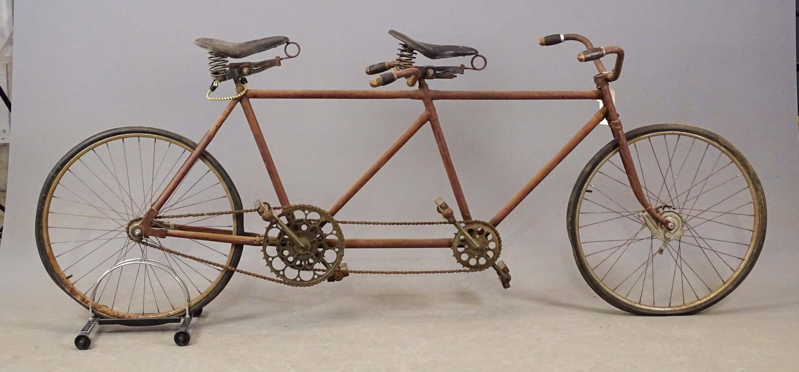 Unknown Maker Tandem Bicycle: Tandem (maker unknown). Built for 2 men (front and back positions). This tandem has only one brake that is a hub brake on the front wheel. There is an over-size chainring on the rear rider