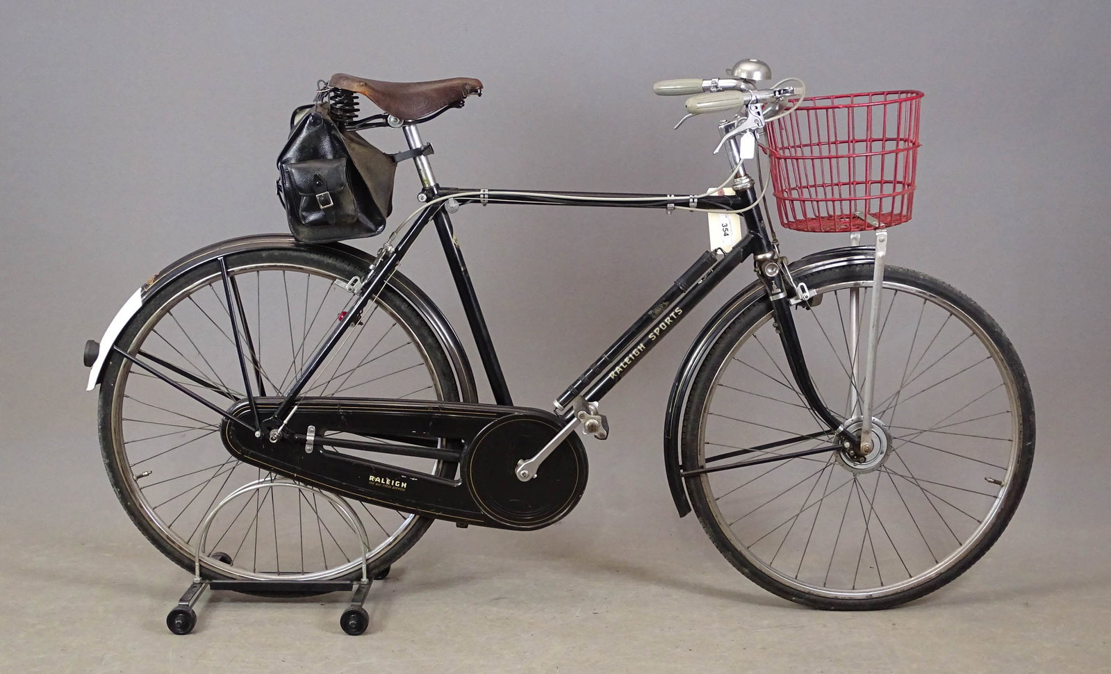 Raleigh Sports Bicycle: Raleigh Sports. Rear hub is Sturmey Archer AW date stamped 1953. Nice enclosed chain case. Front Dyno hub lighting system. Brooks saddle. Great front basket and bell. Nice original paint and decals. R