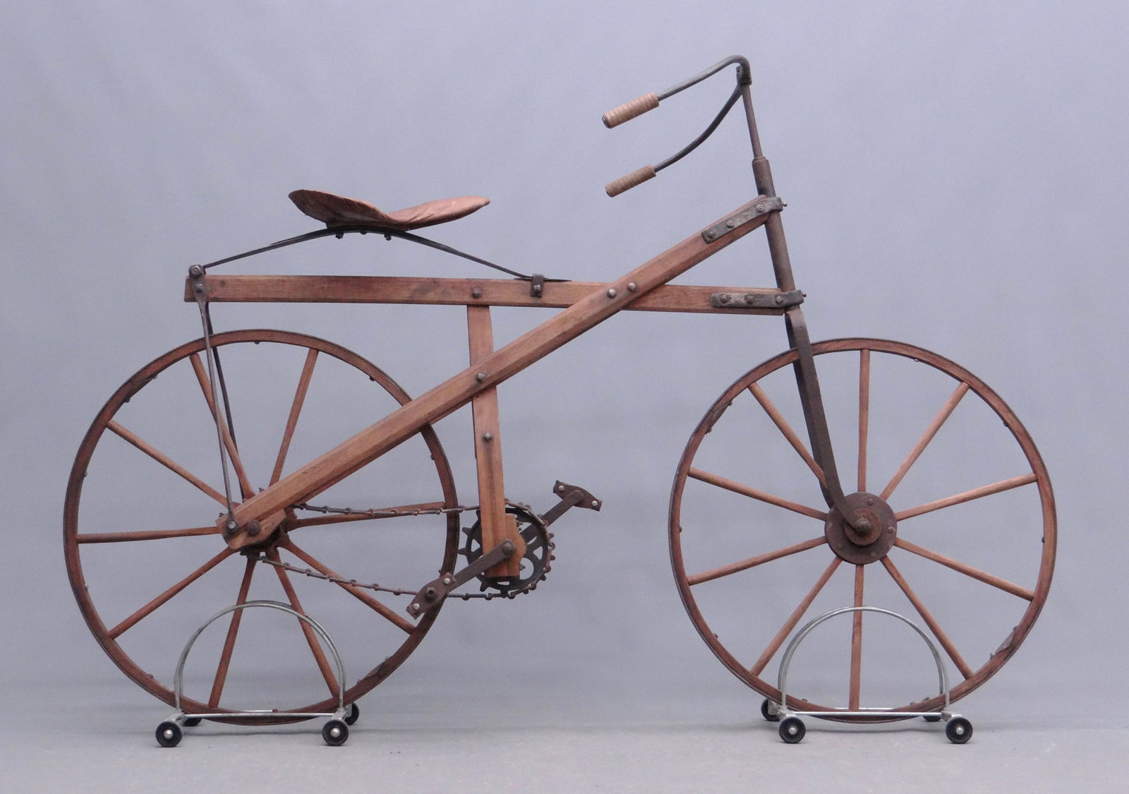 Wooden Bicycle: Primitive wooden chain driven bicycle. Good condition. 50 1/2" Ht., 75" length. David Metz Museum. Previously sold at Copake Auction April 2014, lot 394.