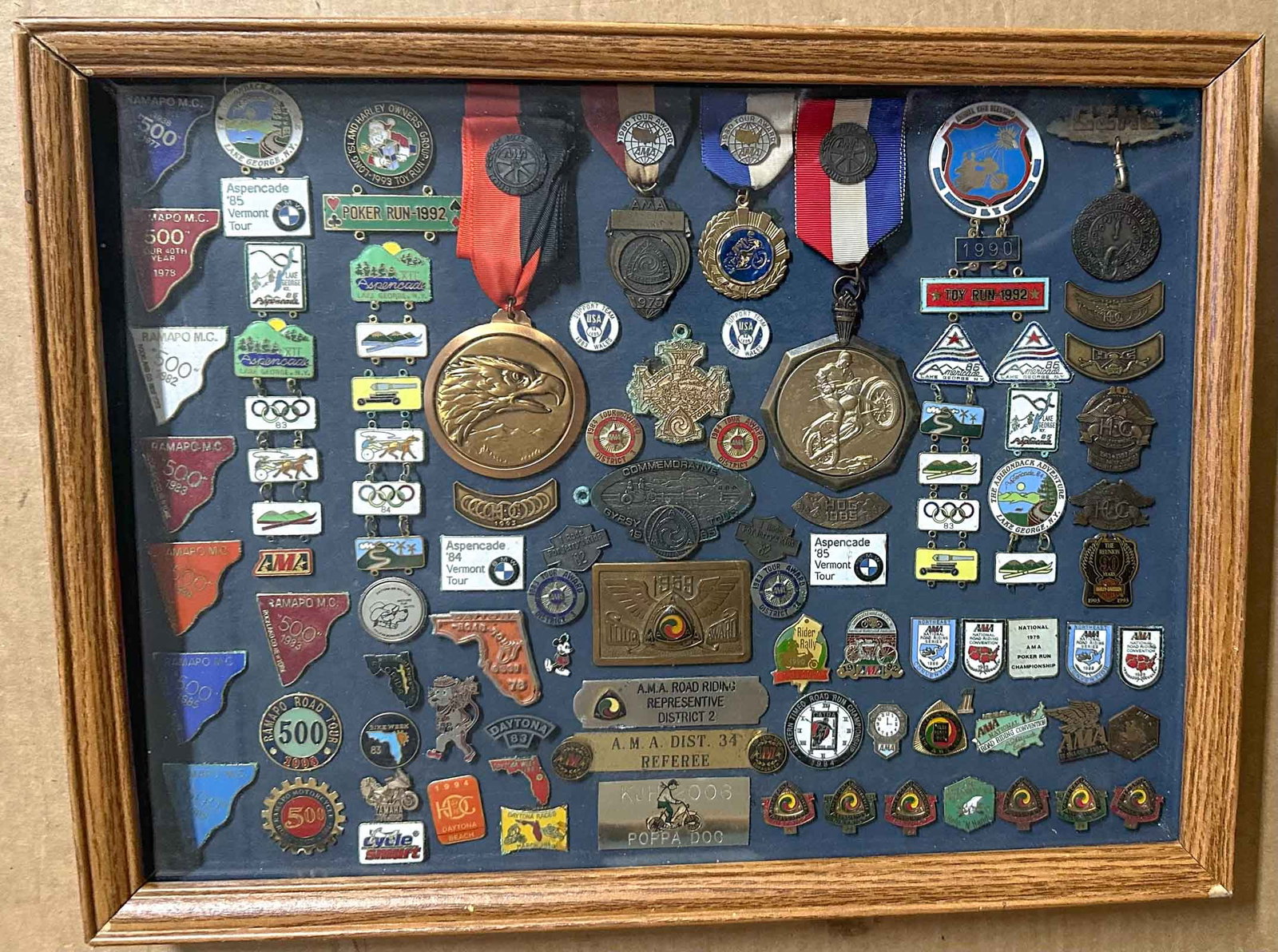 Motorcycle Badges: Motorcycle badges and event medals, Gypsy Tour and others, most are from the 1980's, some 1970's and 1990's, in glass display case.