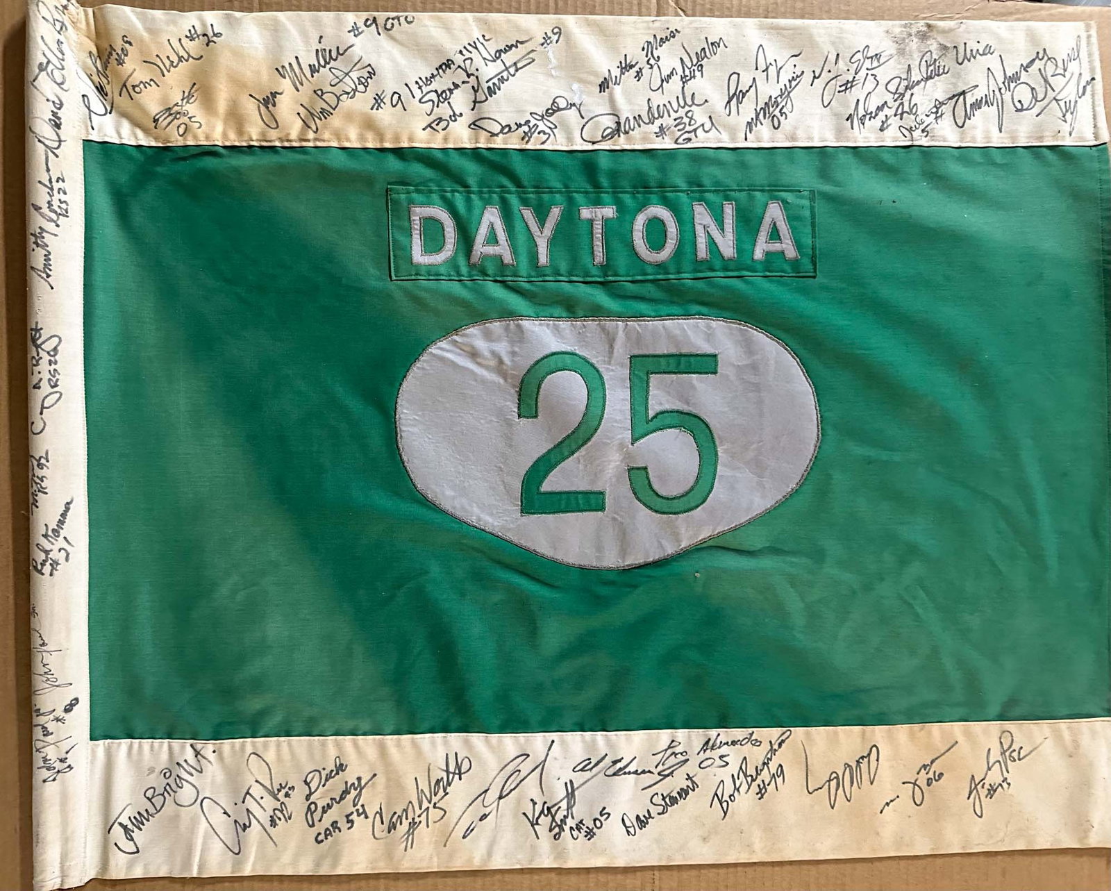 Daytona Autographed Flag: Daytona 25 autographed flag, heavy multi layer cloth sewn,many drivers autographs on both sides and pole edge, 36 x 29.