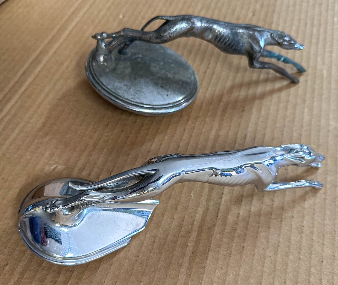 Mascots Lot: Two greyhound radiator mascots, original 1934 Ford accessory , part no 40-18385 cast in base, Williams # 101 and 1932 - 1934 Lincoln Model K cap.