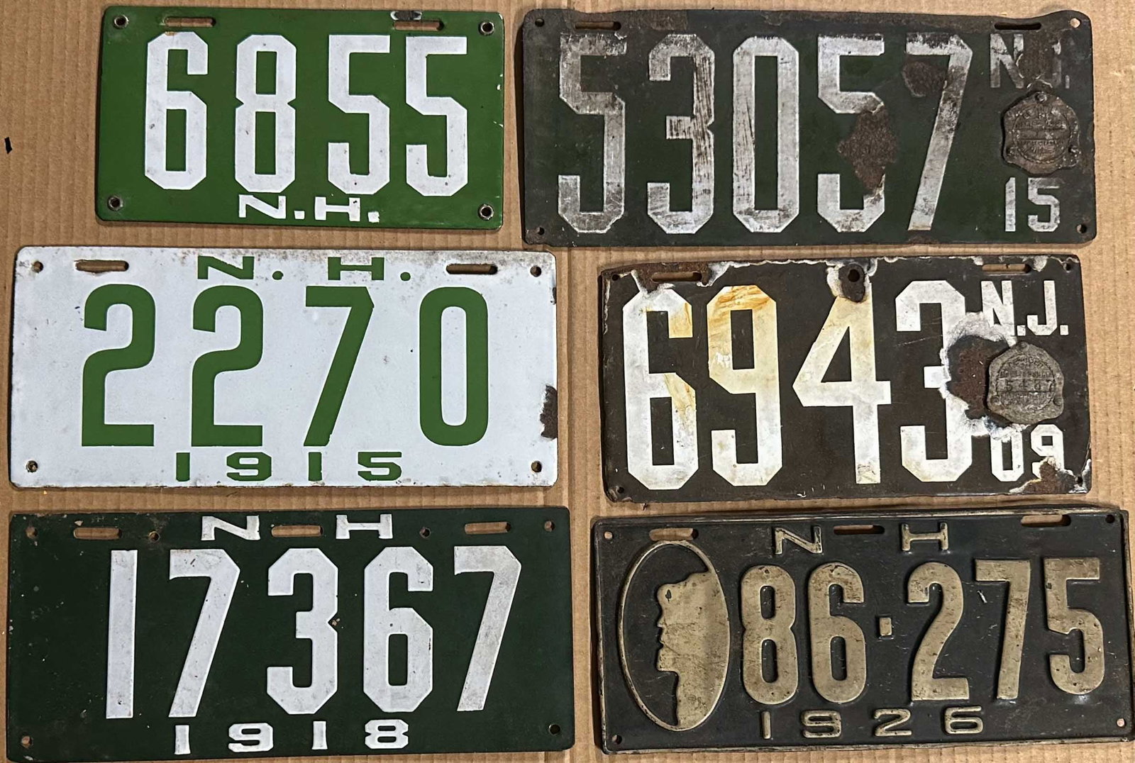License Plates: Four New Hampshire porcelain, undated #6855, ca 1905 - 1909, 1915, 1918, painted 1926, New Jersey 1909, 1915 in fair condition.
