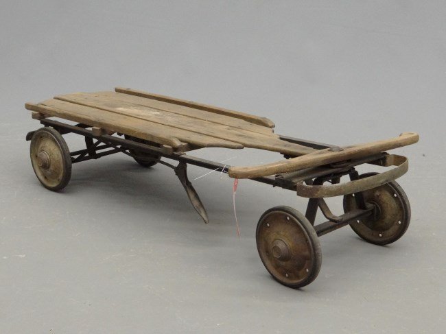 Wooden Sled: Unusual wooden sled with metal runners and disc wheels. Fair condition.