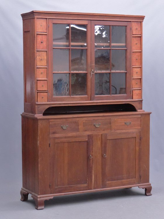 Cupboard: Two part cupboard, top has two glass doors flanked by small apothecary drawers, base with three drawers over two doors. Case rests on bracket base. 56 x 19 1/2" x 6' 9" Ht."