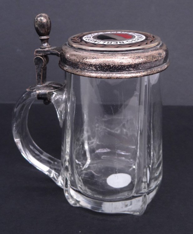 Stein: Glass stein with a silver lid featuring a porcelain insert depicting the crest of the Berliner Bicycle Club Germania" - 5" Ht. Good condition."