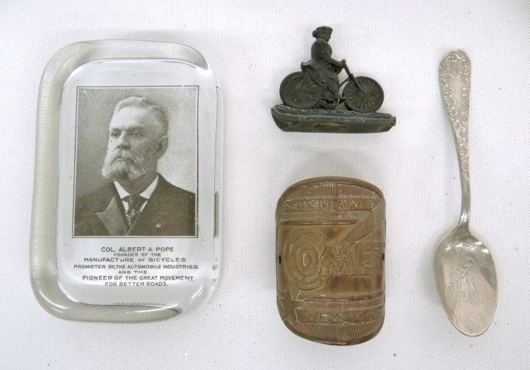 Bicycle Collectables: Lot Col. Albert A. Pope paper weight, bicycle head badge Comet" Progressive Cycle Co. NY, gutta percha cyclist figure, souvenier spoon "N.E. Cycle Show Boston 1897", very good condition."