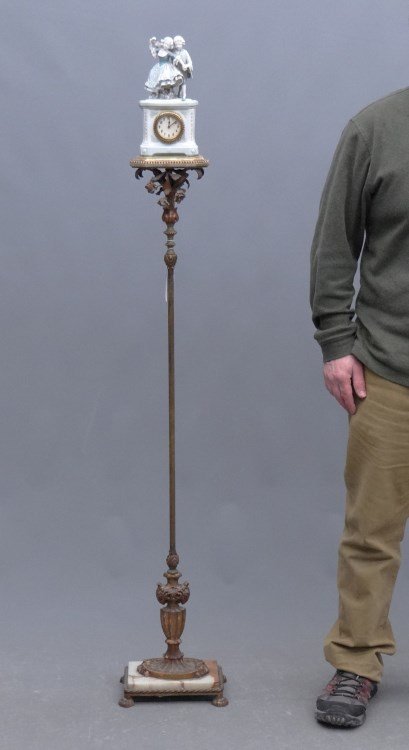 Clock On Lamp Stand: Vintage clock on lamp stand. Porcelain figural clock. 58" overall Ht.