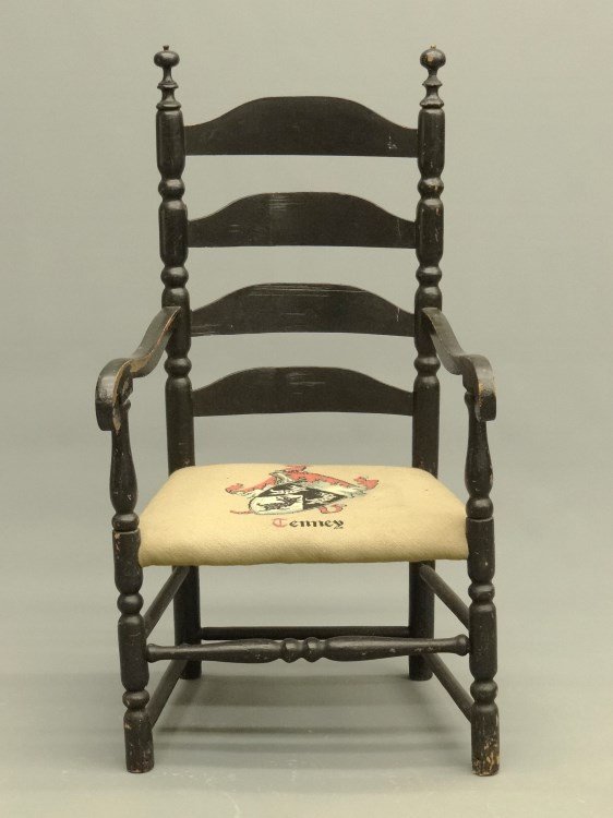 18th c. Ladderback Armchair: 18th c. ladderback armchair in black paint. Seat has needlepoint coat of arms "Tenney". 15" seat Ht., 42 1/2" overall Ht. Has paper with Tenney family provenance.