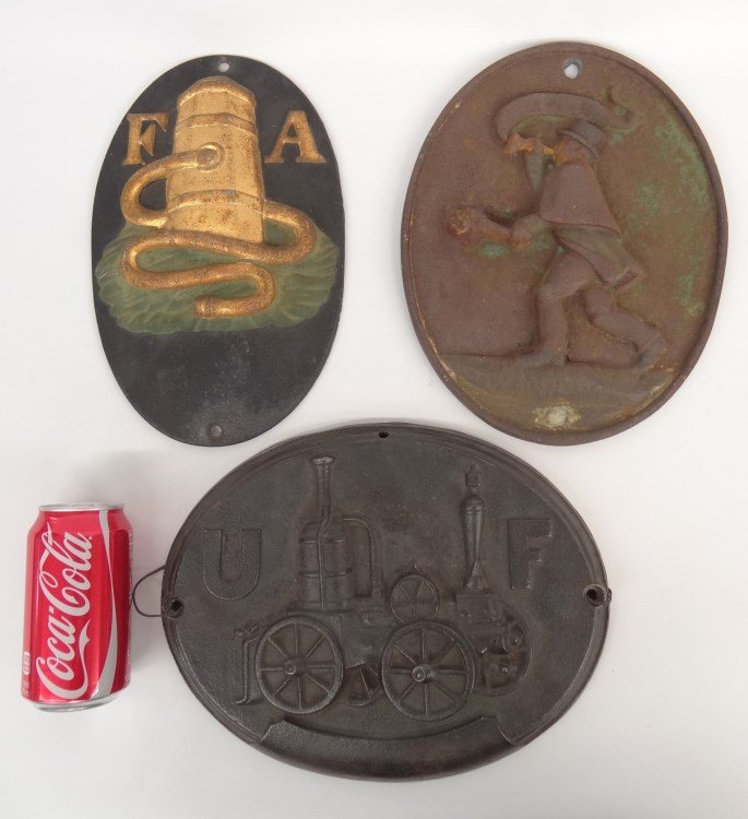 Firemark Collection: Collection of (3) cast iron Firemark, fire engine "UF" (United Fireman Co.) 9 3/4" x 12", pump and hose "FA" 11 1/2" x 7 1/4", fireman with horn 11 1/2" x 9".