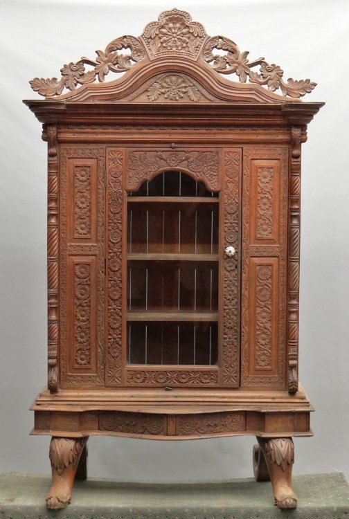 Mahogany Carved Cabinet: Mahogany carved two part cabinet. Top has carved crest over single glass door. Base with carved feet. 51" x 21" x 7' 1" Ht.