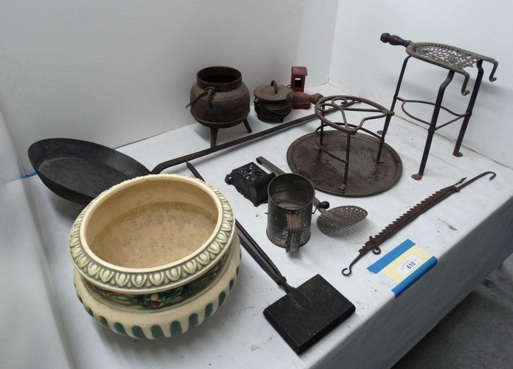 Metalware Lot: Early metalware lot including adjustable trammel, long pan, matchsafe, brass trivets, waffle iron, cast iron pots etc., along with Roseville style Jardineer (as found). (13) pieces.