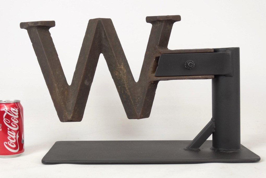 Windmill Weight: Letter "W" windmill weight. Made by The Althouse Wheeler Company, Waupun, Wisconsin. The "W" represents the town of "Waupin". C. 1910-20, for use on their Raymond windmills. Mounted on custom base.