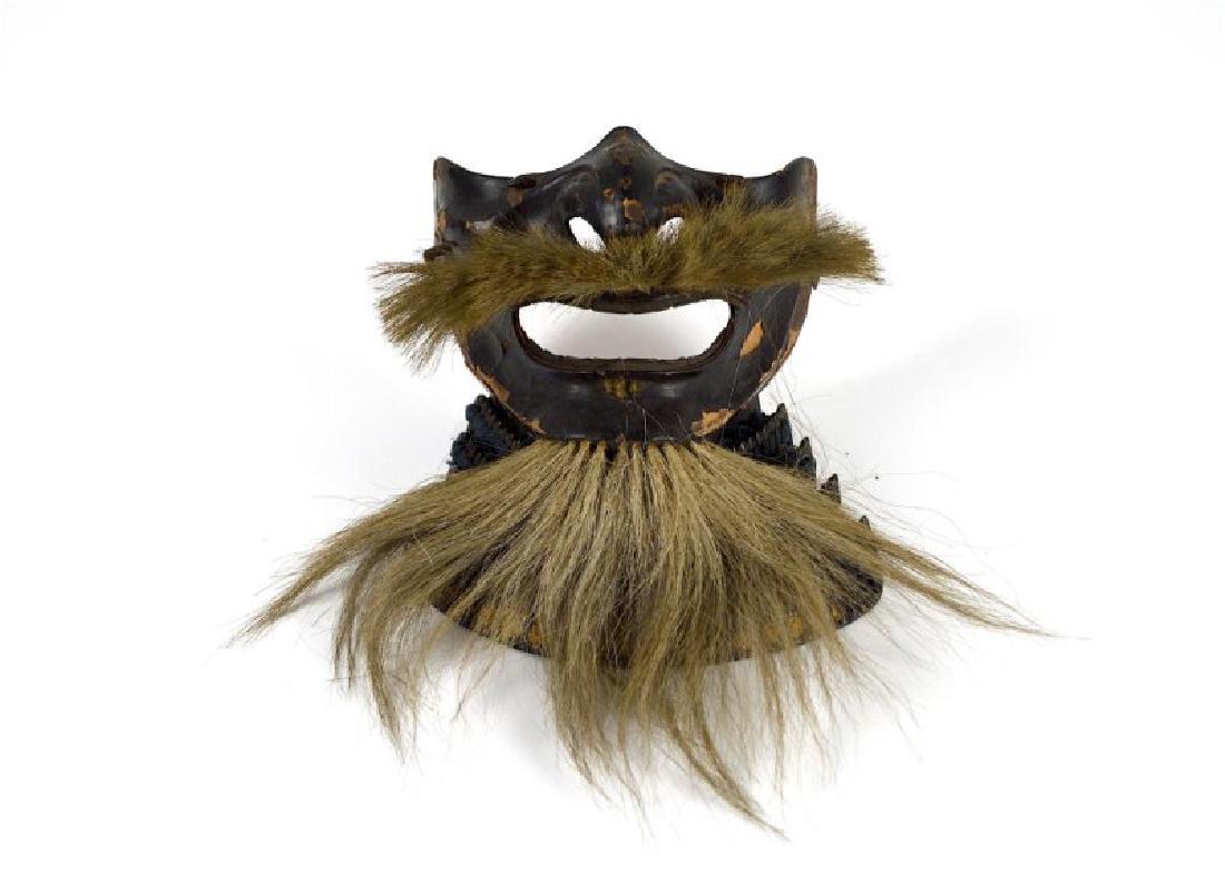 JAPANESE EDO PERIOD SAMURAI MEMPO HALF MASK: Mask with black lacquer on the exterior and red lacquer on the interior. Neck protection tied together with fabric. Mustache and beard made of natural hair. Width: 16cm (6 1/2 in.)