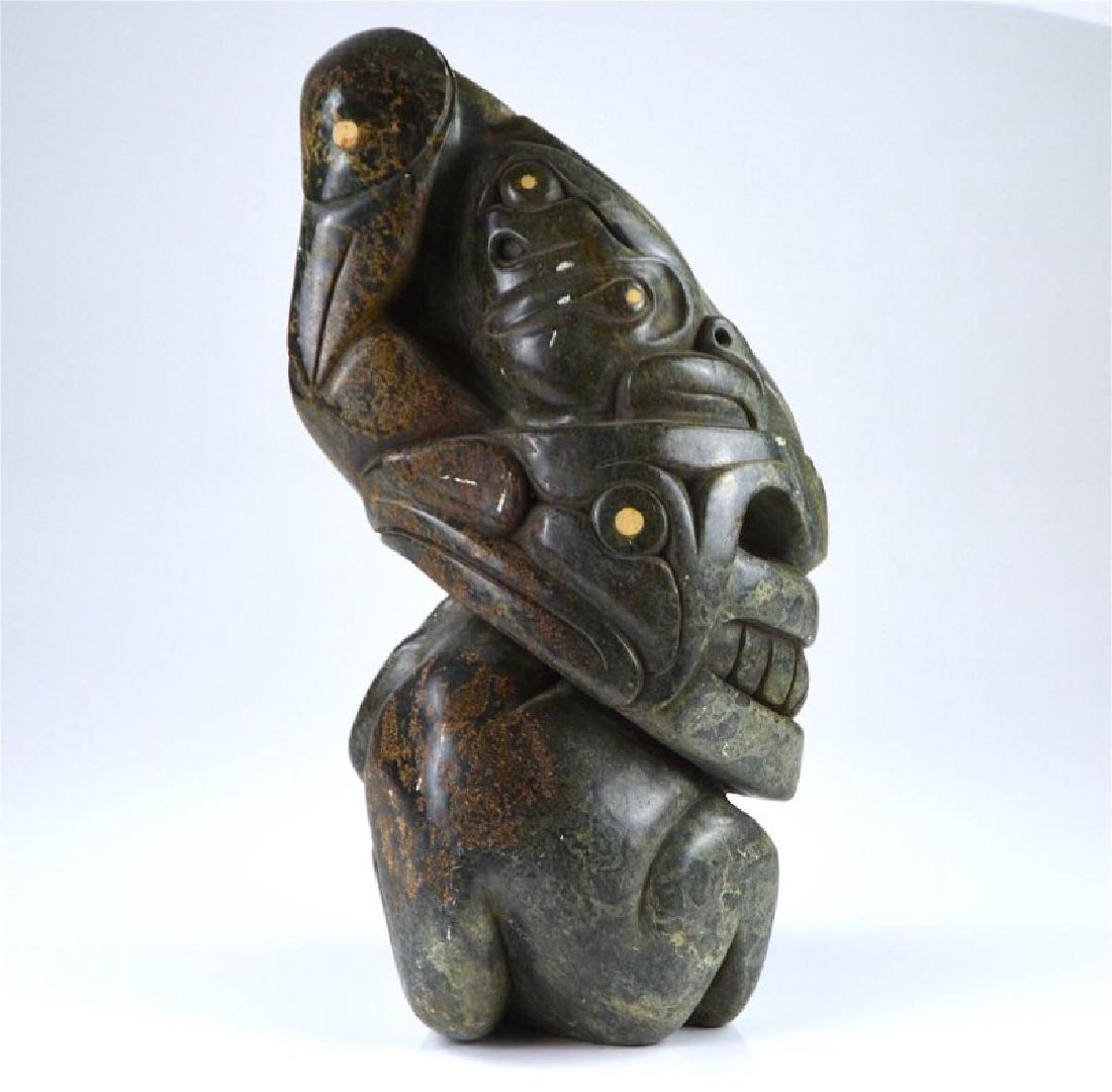 ABRAHAM ANGHIK RUBEN (1951 - ): Eagle, wolf, owl transformation. Pyroxene. Signed along edge of base. Paulatuk, Northwest Territories. H 19 in. (48.26 cm.)