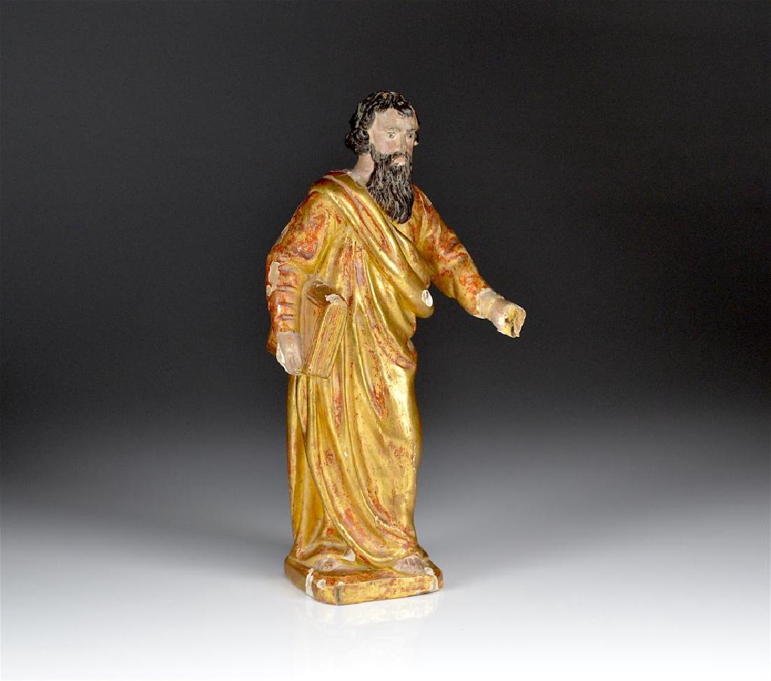 AN EARLY CARVED SAINT FRAGMENT: Of Moses or an apostle, holding a book and draped in a robe, gesso and gilded decoration, 18th C. H 26.5 cm (10 1/2 in) Provenance: From a Montreal estate of a known andrespected collector.