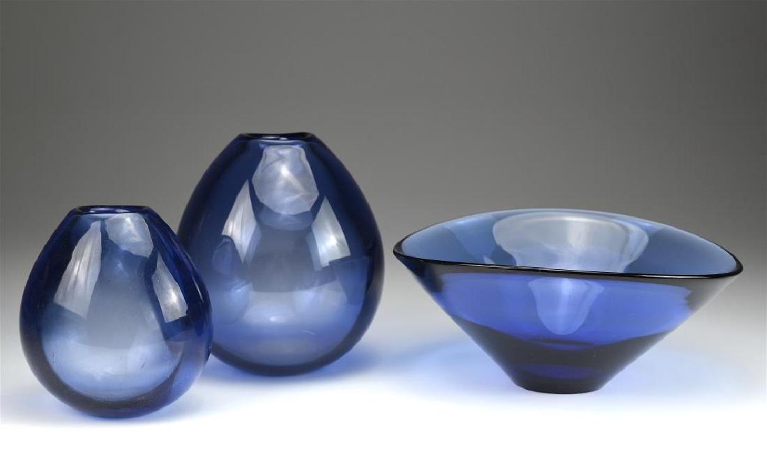 Three Holmegaard glass pieces by Per Lutkin: Two Soap Bubble vases and a bowl in blue. Each signed with monograph and numbered 17268, 15470 & 290262. H of largest vase 16 cm (6 1/4 in)