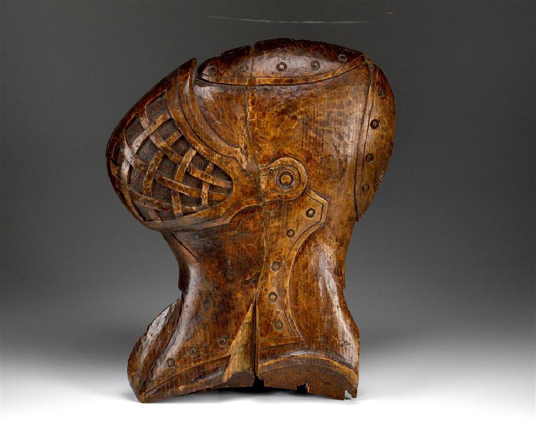 Carved wood plaque of armour helmet (1 of 2)