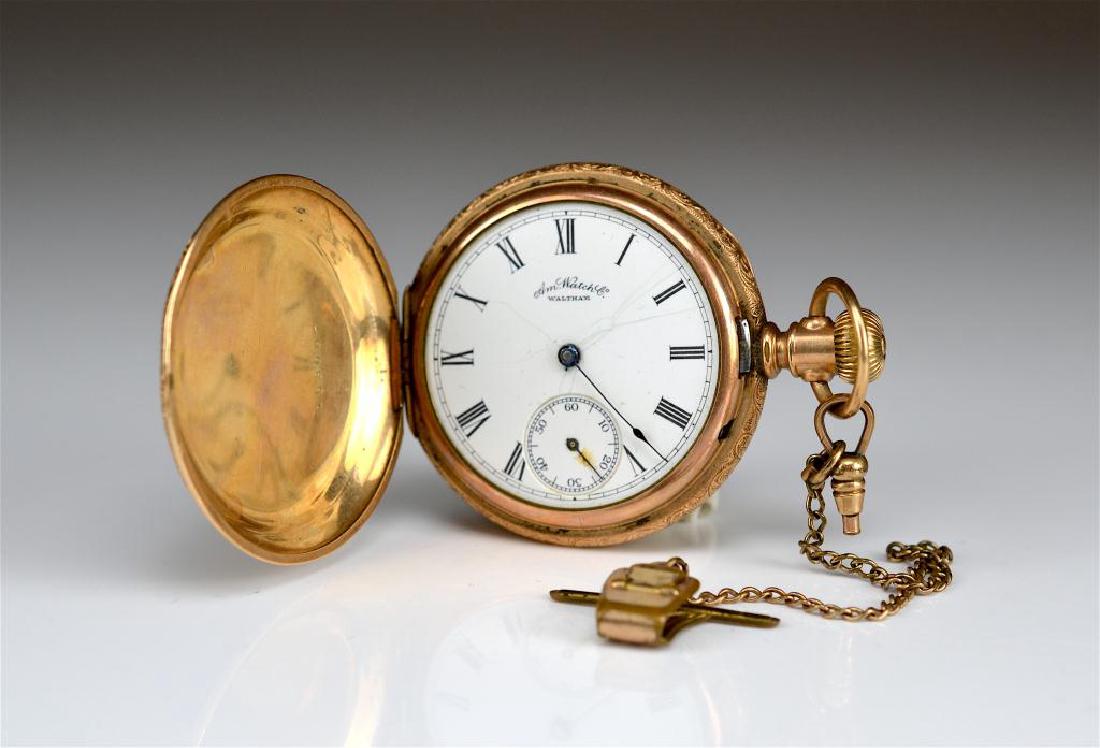 Waltham gold-filled hunter pocket watch: Decorated with scroll and foliate motif, with vest clip. D. 5cm.