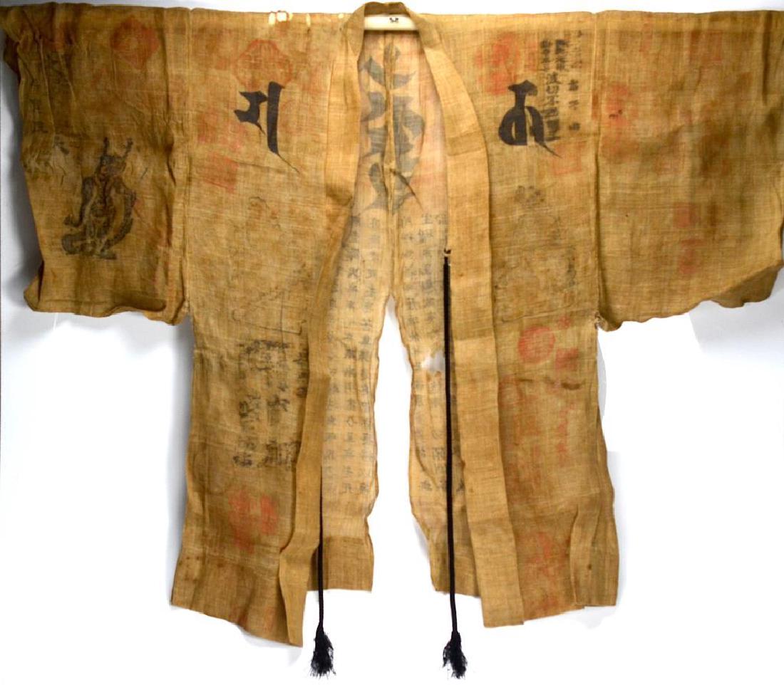 JAPANESE BUDDHIST PILGRIM'S COAT: Calligraphy of the Heart Sutra to back together with Sanskrit. Pilgrim red stamps all over as well as metal buttons collected from pilgrimage sites attached to the belt. Early 20th C. Size: 100 x 126c