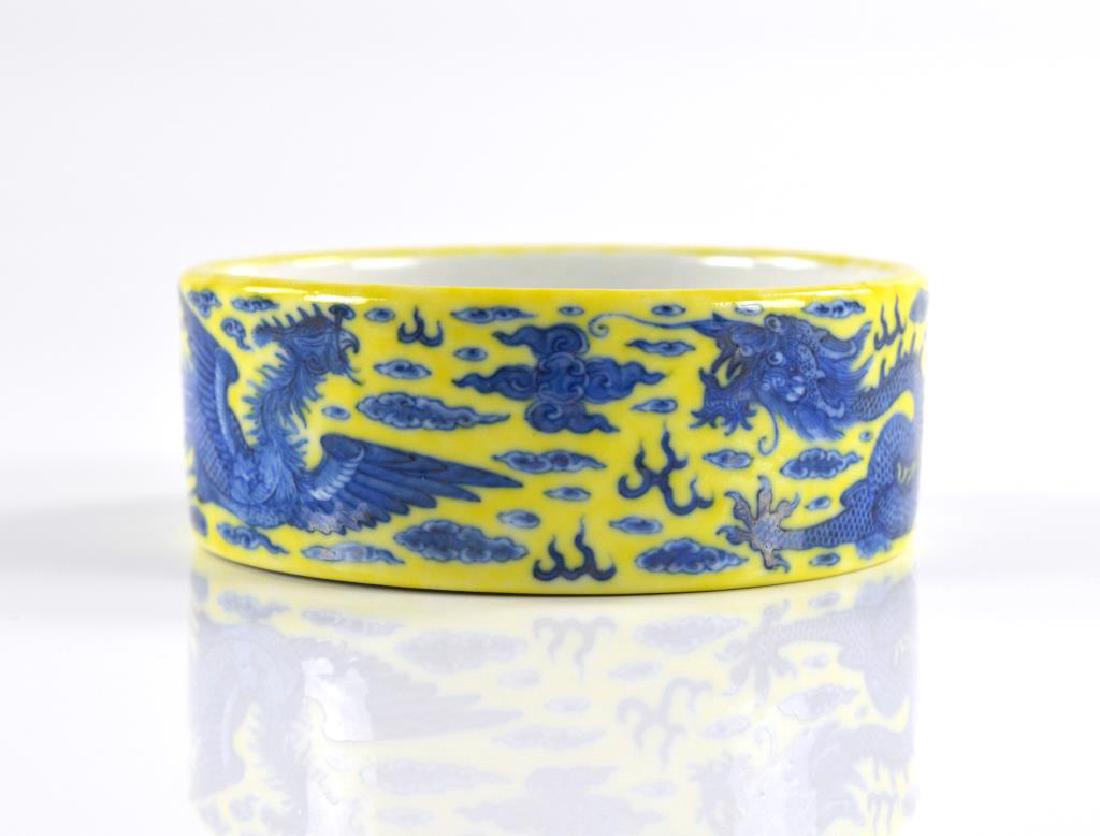 CHINESE YELLOW GROUND PORCELAIN BRUSH BOWL: Painted in cobalt blue with dragon and phoenix among clouds. Six character cobalt blue Qianlong mark to base. Dia. 14.2cm (5 5/8 in.)